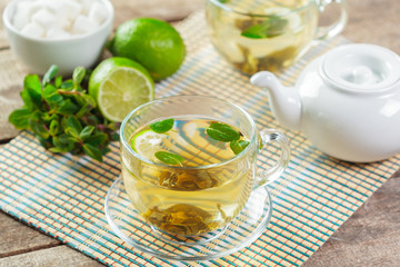 cup of black tea with mint leaves on a wooden table
