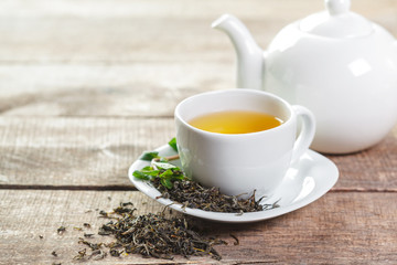 cup of black tea with mint leaves on a wooden table