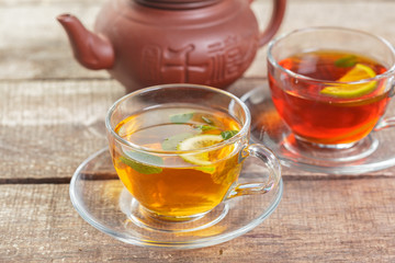 cup of black tea with mint leaves on a wooden table