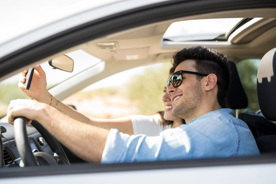 Couple taking selfie on a long drive