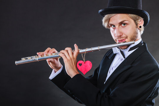 Male flutist with flute and heart. Love melody