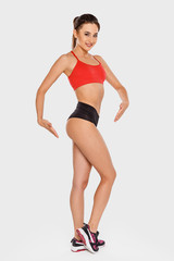 Slender young woman in sports clothes shows her beautiful legs