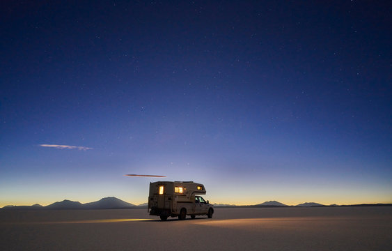 Recreational vehicle, travelling at dusk, across salt flats, Salar de Uyuni, Uyuni, Oruro, Bolivia, South America