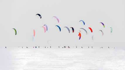 Lot of kites in the snowy wilderness in the sky. Concept: sportsmen snowkiting at sport winter...