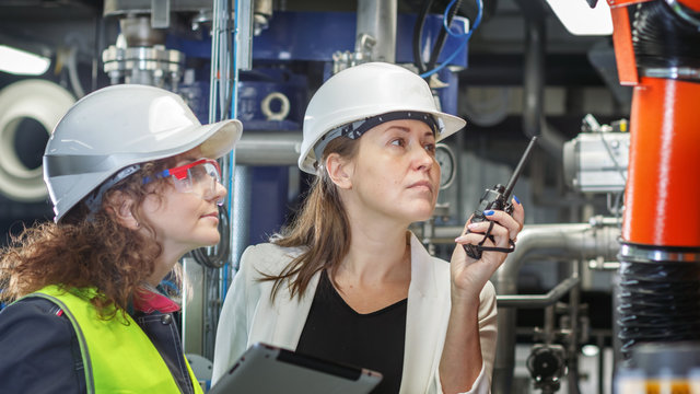 Girl and the girl working the engineer check the equipment. They're connected on a walkie-talkie.