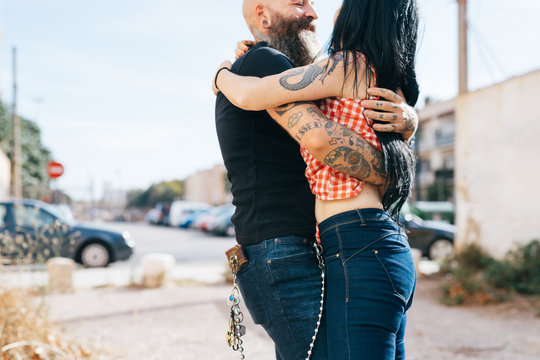 Mature hipster couple hugging each other