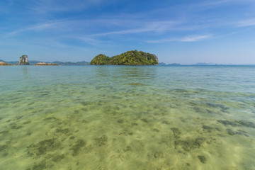 On the island where clear blue sea, bright blue sky, white sandy beach in summer.