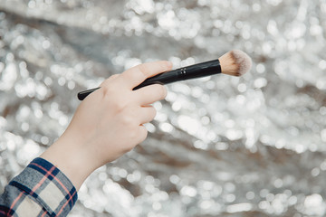 Makeup brush. A woman make-up artist holds make-up brush.