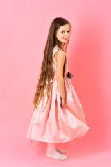 Little girl with long hair on pink background.