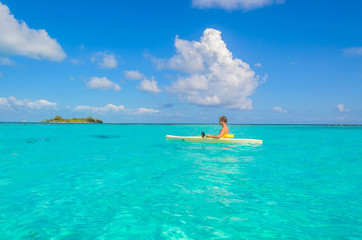 Fototapeta na wymiar Kayaking in tropical paradise - Canoe floating on transparent turquoise water, caribbean sea, Belize, Cayes islands