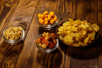 Mix of snacks for beer on wooden table