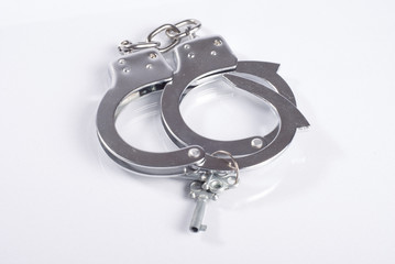 Handcuffs with a key on white background