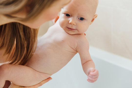 Mother bathing baby daughter