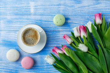 Tulips with macaroons on blue wooden background
