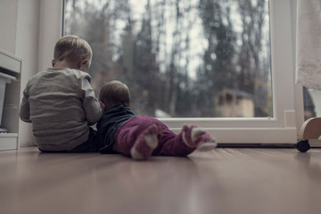  Toned image of brother and sister sitting on the wooden floor