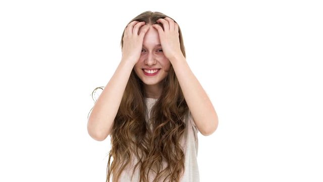 Portrait of gorgeous young woman 17y waving head with floating brown hair and smile in slow motion, isolated over white background closeup. Concept of emotions