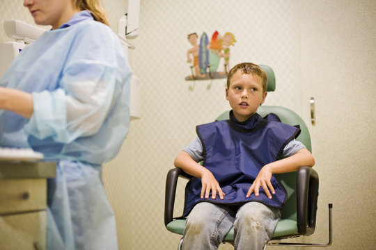 Boy sitting on chair at dental clinic