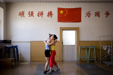 Young adult girl hugging a team mate in a gym.