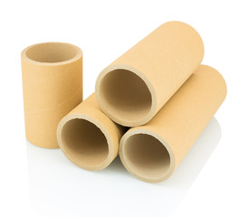 A bunch of brown industrial paper core isolated on white background with shadow reflection. A lot of paper cores or paper tubes on white backdrop. Brown paper rolls.
