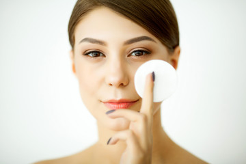 Skincare. Young woman with lotion washing face at bathroom