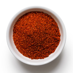 Red bbq spice mix in white ceramic bowl isolated on white from above.