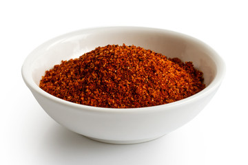 Red bbq spice mix in white ceramic bowl isolated on white.