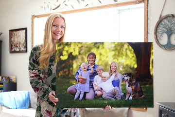 Happy Young Woman Holding Canvas Print of Family Portrait