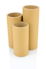A bunch of brown industrial paper core isolated on white background with shadow reflection. A lot of paper cores or paper tubes on white backdrop. Brown paper rolls.