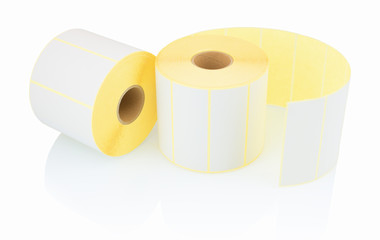 White label rolls isolated on white background with shadow reflection. White reels of labels for printers. Labels for direct thermal or thermal transfer printing. White stickers on white backdrop.