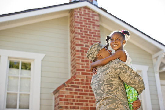 Smiling young girl hugging her father.