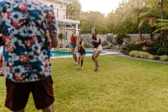 Friends having fun playing with water guns