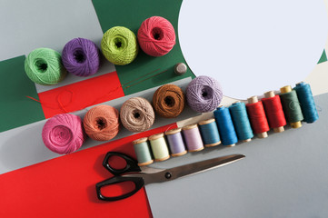 yarns of threads for knitting in different colors on a red green background