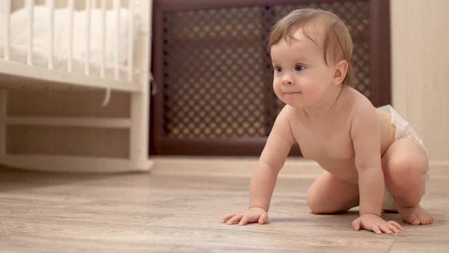 child learns to crawl on floor in the childrens room