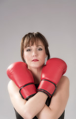 Woman wearing a black leather dress and re boxing gloves