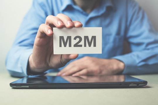 Businessman showing M2M word on business card.