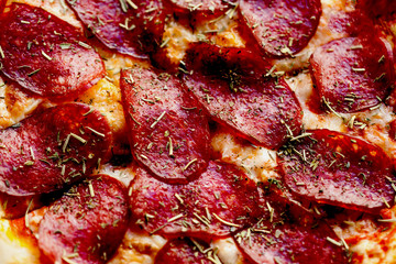Pizza with tomatoes, meat, mozzarella cheese, black olives and herbs. 