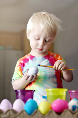 Cute Little Toddler Boy Painting on an Easter Egg