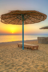 Parasols on the beach of Red Sea in Hurghada at sunrise, Egypt