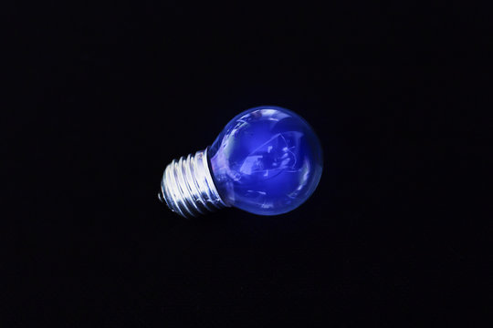 electric blue light bulb on black background