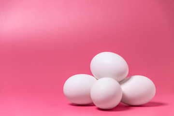 Happy Easter concept. Minimal concept. Front view. White eggs on pink background. Close up. Copy space.