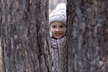 Cute little girl in pine forest in autumn time