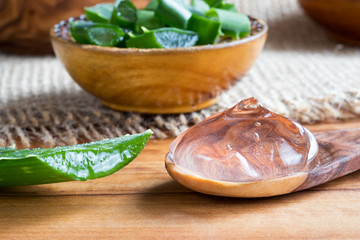 Aloe vera gel with pieces of aloe vera leaves in the background
