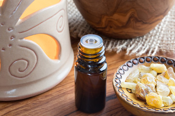 A dark bottle of frankincense essential oil with frankincense resin