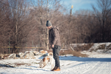 Young dog instructor walking a dog with a behavioral problem helping him with dog training. Canine Rehabilitation Therapist for dog rehabilitation program