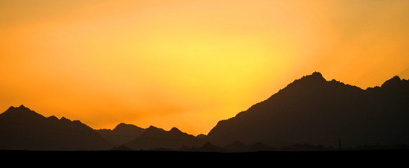 The sun behind the mountains, a beautiful sunset, the sun sets behind the mountains