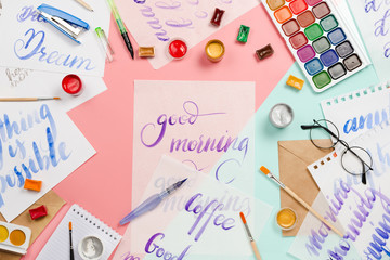 Beautiful flatlay arrangement with watercolors, brushes, glasses, brushpen, paints with good morning handlettering and other stationary and art supplies. Creativity or education concept