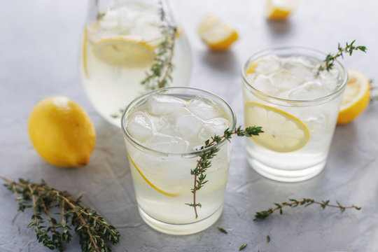 Homemade Summer Drink With Lemon, Thyme And Ice In The Glasses On The Table.