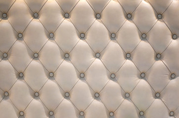The surface of a white leather quilt sofa as a background