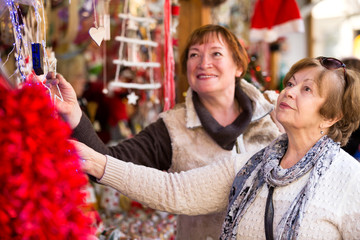 Happy mature women purchasing Christmas decorations
