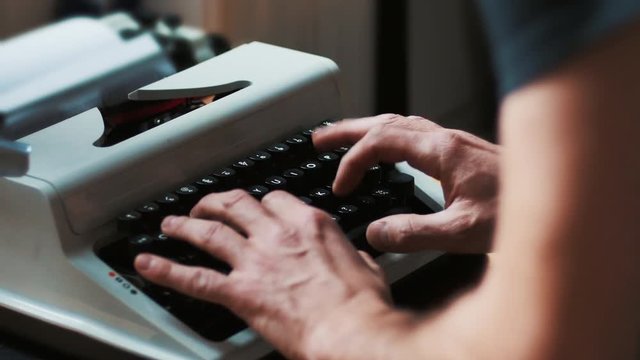 Hands typing a film script or a book on a vintage typewriter, 4k video